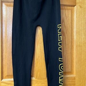 Women Black Leggings with Yellow Print saying New York and thick.
